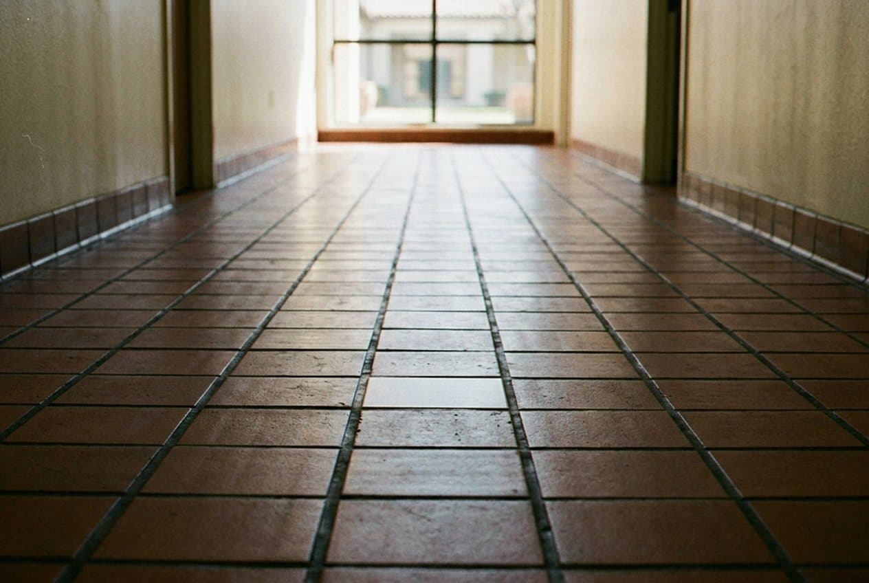 Terracotta tile hallway leading to a sliding glass door